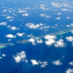 Maldives Exclusive - aerial photography of green island and clouds